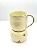 Kremowy, złocony kubek ceramiczny z podgrzewaczem.