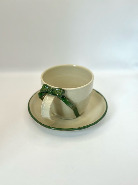 Urocza ceramiczna filiżanka z zielona kokardką ze spodkiem 200 ml. Urocza ceramiczna filiżanka z zielona kokardką ze spodkiem 200 ml.